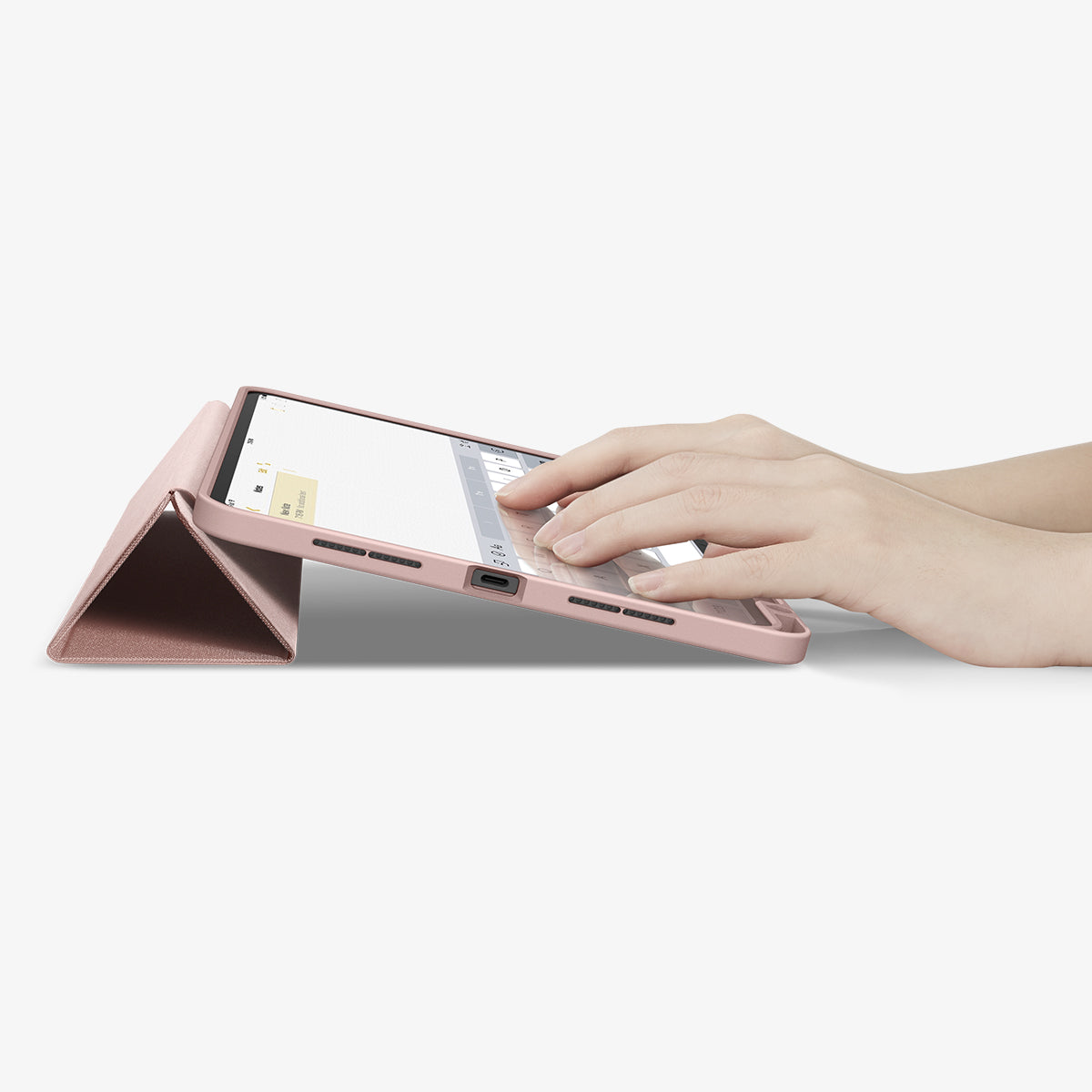 ACS07021 - iPad Pro 11-inch Case Urban Fit in Rose Gold showing the partial front with a hand typing on the device with a folded front cover propped up as a stand