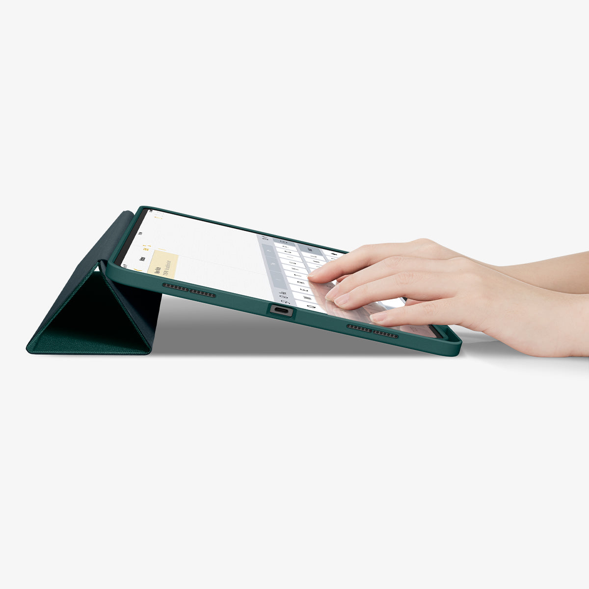 ACS07763 - iPad Pro 13-inch (2024) Case Urban Fit in Midnight Green showing the partial front with a hand typing on the device with a folded front cover propped up as a stand